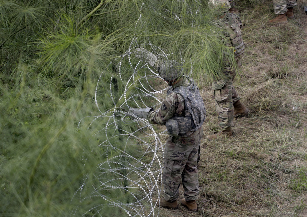 Members of the U.S.military place razor wire along the U.S.-Mexico border near the McAllen-Hidalgo International Bridge, Friday, Nov. 2, 2018.
